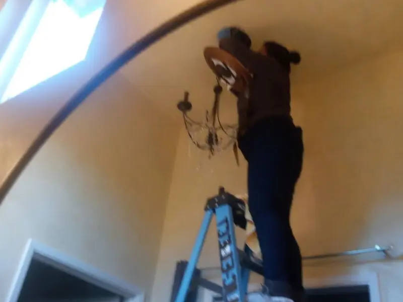 Electrician installing a chandelier in a Grottoes residence